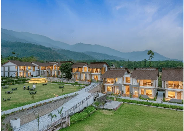 Evara Spa & Resort lawns and cottages with the Kumaon foothills rising behind, near Jim Corbett National Park